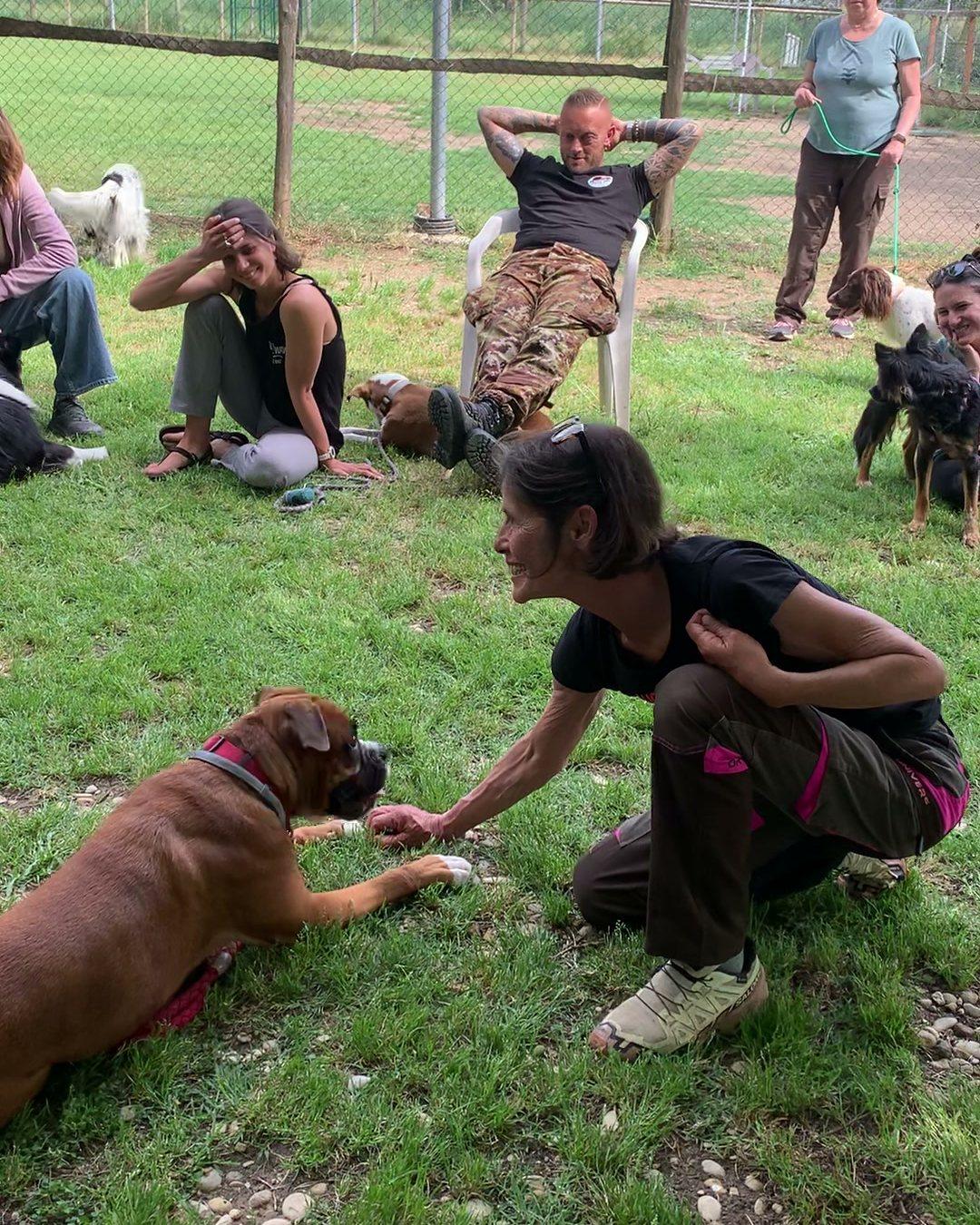 Liliana Tamberi, docente del corso, durante una lezione pratica con un boxer, con gli allievi seduti sul prato dell'Accademia AICSS a Roma