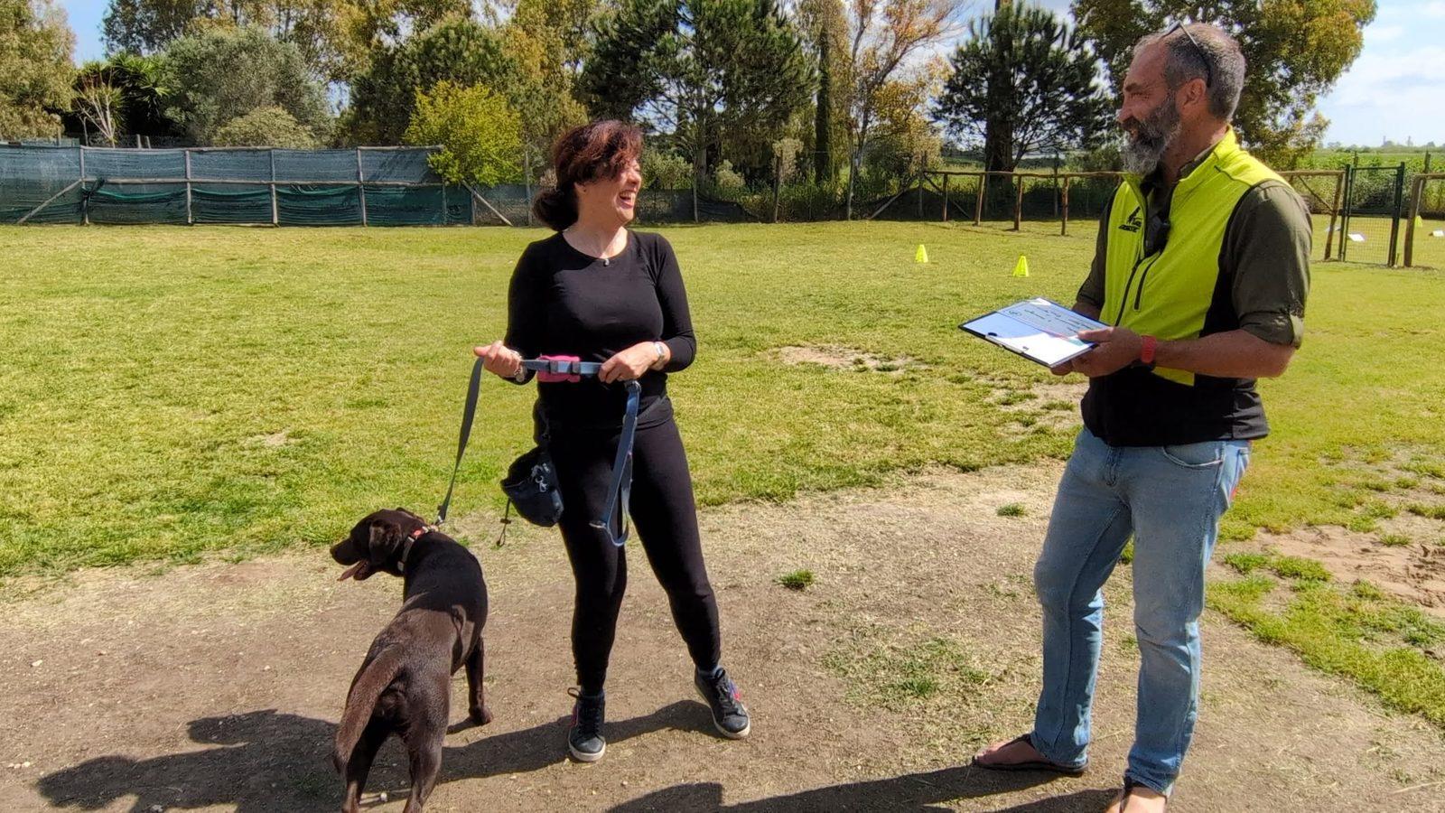 Prova finale di Obedience: una conduttrice con il suo cane e l'istruttore con la scheda